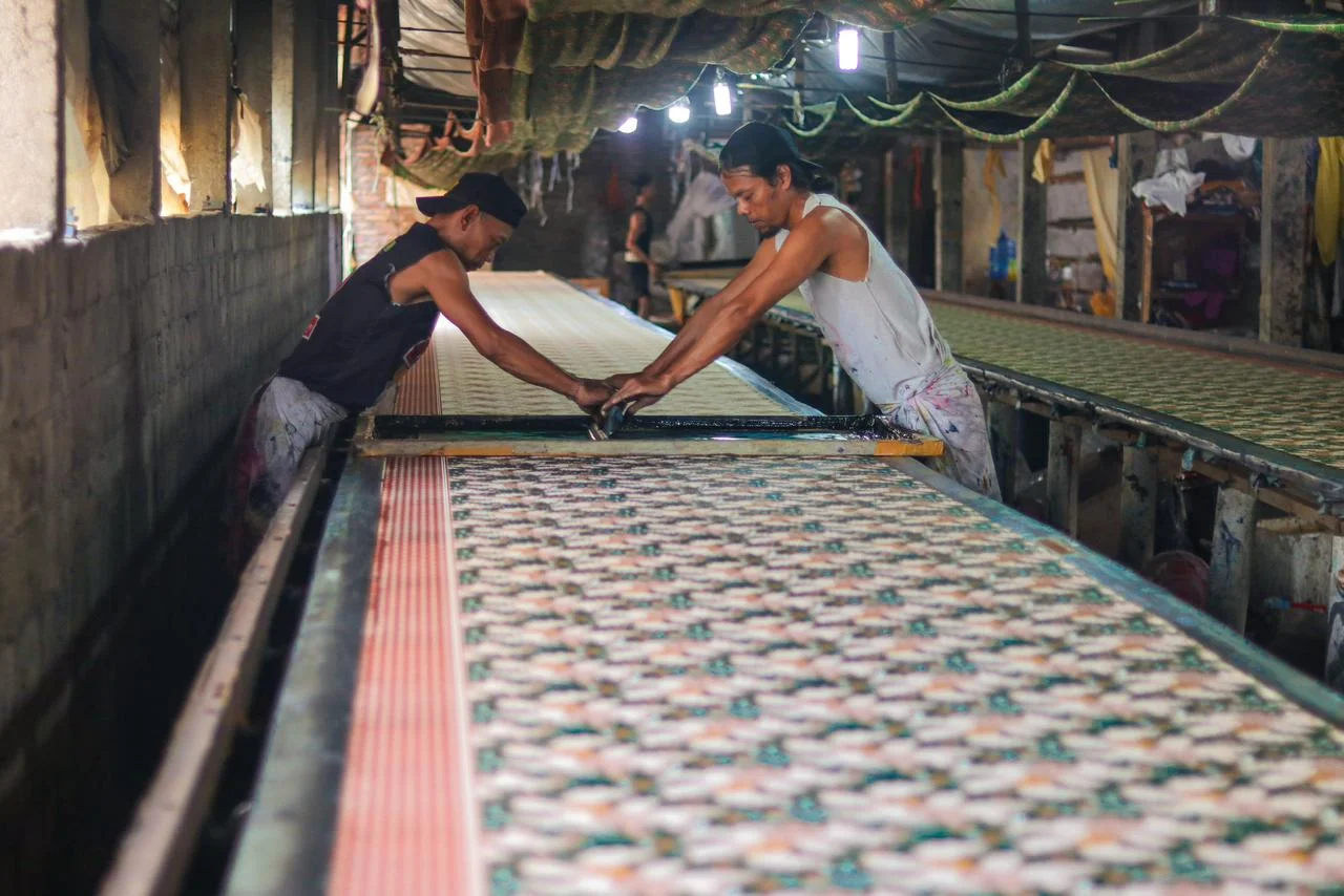 Pekerja di meja printing batik panjang